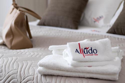 two beds with white towels and a hotel sign on them at Alludo Aparthotel b&b in Agrigento