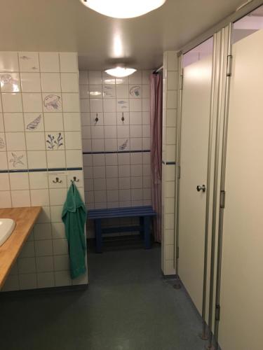 a bathroom with a sink and a bench in a room at Grebbestads Vandrarhem in Grebbestad