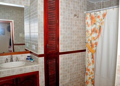uma casa de banho com um lavatório e uma porta vermelha em Finca Cielo Verde em Chicoana