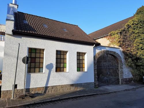 a white building with a gate and a shadow of a person at Pension Haus Baron 4 Mühlheim in Mühlheim