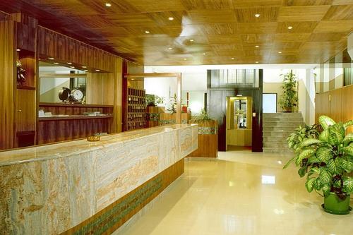 a lobby with a reception counter and a staircase at Hotel Genzianella in Cervia