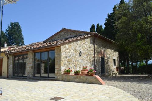 a stone building with windows and flowers in front of it at Tenuta Poggio ai Mandorli in Greve in Chianti