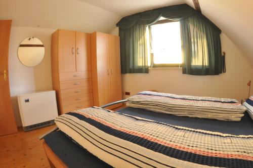 ein Schlafzimmer mit einem großen Bett und einem Fenster in der Unterkunft Gemütliche FeWo - Tannenhof in Oßling