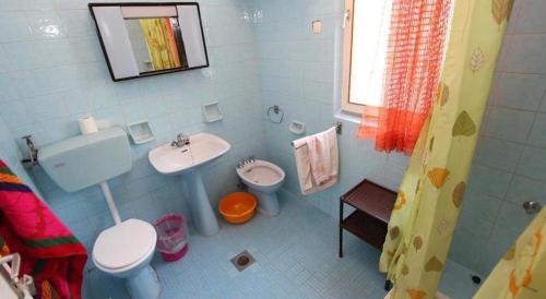 La salle de bains bleue est pourvue d'un lavabo et de toilettes. dans l'établissement House Paulina 1214, à Banjole