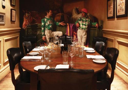 a table in a restaurant with two men standing around it at Hotel Du Vin & Bistro York in York