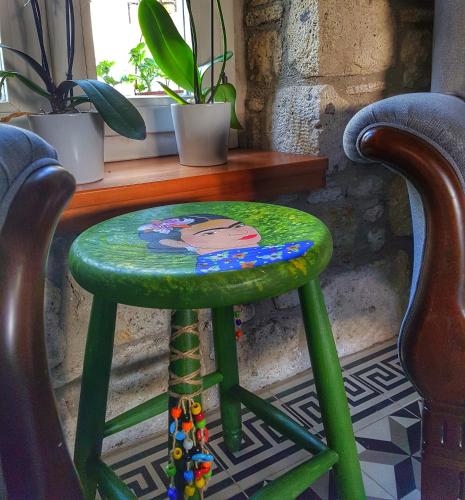 a green stool with a picture on it next to two chairs at Maison d'Azur Alaçatı in Alacati