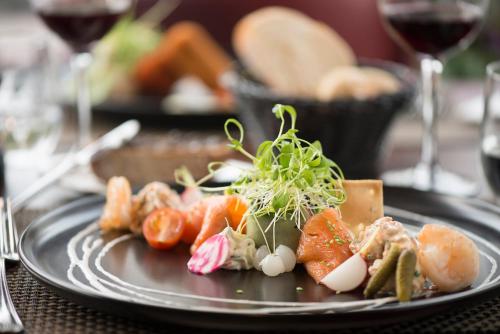 a plate of food on a table with wine glasses at Charmehotel Klokkenhof in Brasschaat