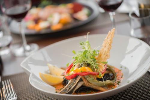 a plate of food on a table with wine glasses at Charmehotel Klokkenhof in Brasschaat