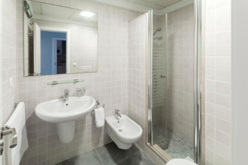 オリーバにあるCamelotの白いバスルーム(シンク、シャワー付)