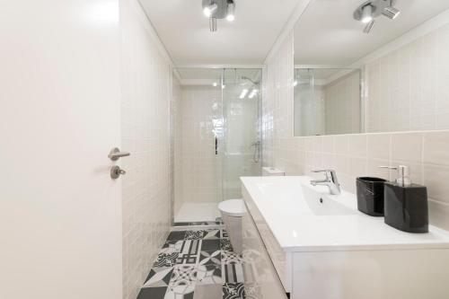 a bathroom with a sink and a toilet and a mirror at LovelyStay-Modern Loft City Center in Porto