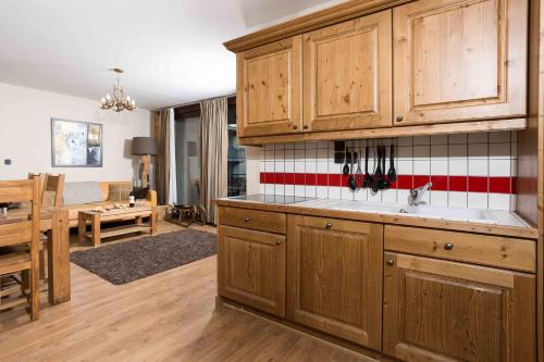 une cuisine avec des placards en bois et un salon dans l'établissement Le Paradis 8 apartment - Chamonix All Year, à Chamonix-Mont-Blanc