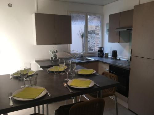 uma cozinha com uma mesa com guardanapos e copos amarelos em Maison de vacances à Dieppe em Dieppe