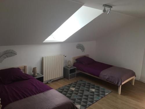 um quarto no sótão com 2 camas e uma janela em Maison de vacances à Dieppe em Dieppe