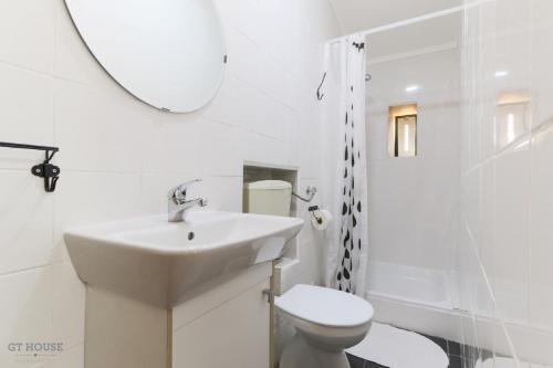 uma casa de banho com um lavatório, um WC e um espelho. em Pateo da Paz em Lisboa