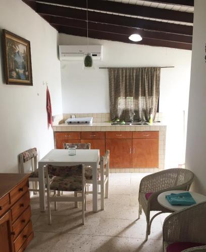 a kitchen with a table and some chairs and a table and a counter at Kasita Jongbloed in Willemstad