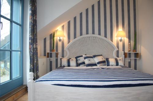 ein Schlafzimmer mit einem weißen Bett mit blauen und weißen Kissen in der Unterkunft Ferienwohnung Urte in Putgarten , Kap Arkona Rügen in Putgarten