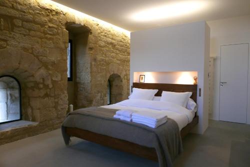 Montaren-et-Saint-MédiersにあるTour Sarrazine de Montarenの石壁のベッドルーム1室(大型ベッド1台付)