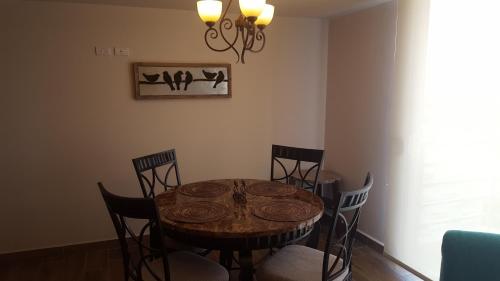 a dining room table with chairs and a chandelier at Apartamentos EcoVivienda in Tegucigalpa