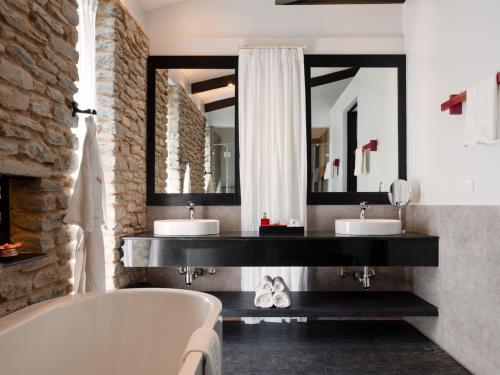 a bathroom with two sinks and a bath tub at The Pavilions Himalayas The Farm in Pokhara