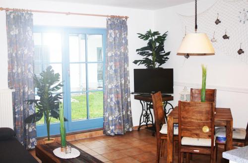 ein Wohnzimmer mit einem TV und einem Tisch mit einem Schreibtisch in der Unterkunft Ferienwohnung Finja in Putgarten, Kap Arkona Rügen in Putgarten