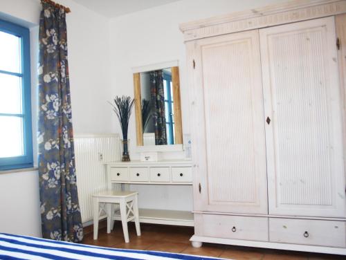 a bedroom with a white cabinet and a mirror at Ferienwohnung Finja in Putgarten, Kap Arkona Rügen in Putgarten