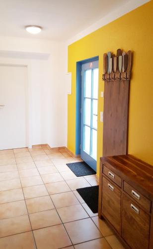 a kitchen with yellow walls and a door with knives at Ferienwohnung Finja in Putgarten, Kap Arkona Rügen in Putgarten