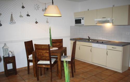 cocina con mesa, sillas y fregadero en Ferienwohnung Finja in Putgarten, Kap Arkona Rügen, en Putgarten