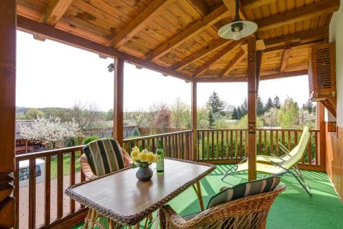 a porch with a table and chairs on a deck at Kaktusz Villa Heviz in Hévíz