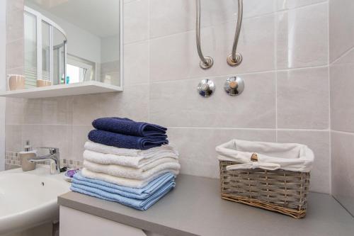 - une salle de bains avec des serviettes sur un comptoir à côté d'un lavabo dans l'établissement Apartments Mate, à Turanj