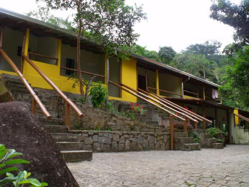 ein gelbes Gebäude mit einer Treppe davor in der Unterkunft Pousada do Horto in Trindade