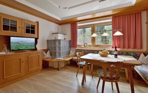 Un comedor con una mesa y un televisor. en Ferienhof Hubertus, en Mayrhofen