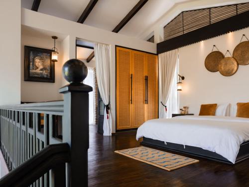 a bedroom with a large bed and a staircase at The Pavilions Himalayas The Farm in Pokhara