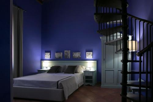 SalemiにあるBaglio Borgesatiの青い壁のベッドルーム1室(ベッド1台付)