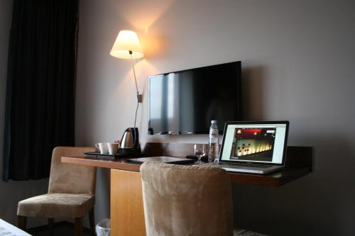 a laptop computer sitting on a desk in a hotel room at Hotel Sirius in Huy