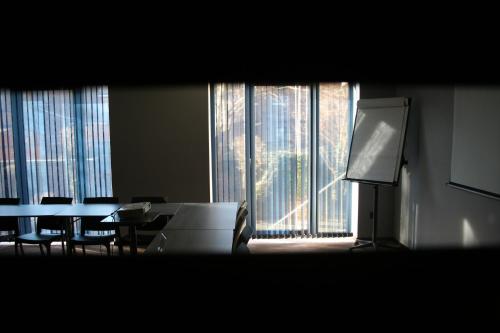 a room with a table and chairs and a large window at Hotel Sirius in Huy