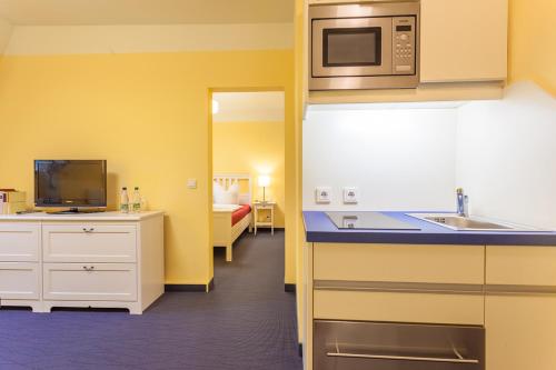 a kitchen with a sink and a microwave at Parkhotel Muldental in Colditz