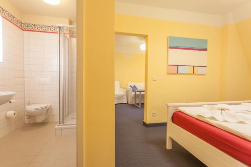 a room with a bathroom with a bed and a sink at Parkhotel Muldental in Colditz