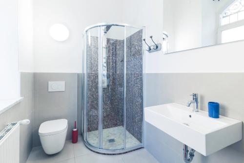 La salle de bains est pourvue d'une douche, d'un lavabo et de toilettes. dans l'établissement Bolzano Rooms, à Bolzano