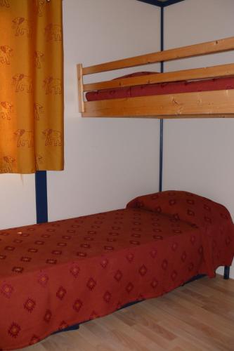 a red bed in a room with a bunk bed at Orbitur Ilha de Armona in Olhão