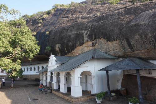 a small white building next to a mountain at The Green Village Dambulla in Dambulla