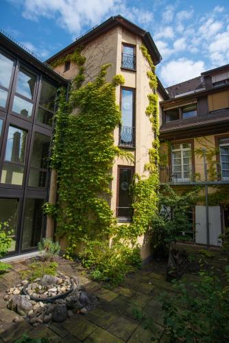 an ivy covered building with a garden in front of it at Zum Roten Bären in Freiburg im Breisgau