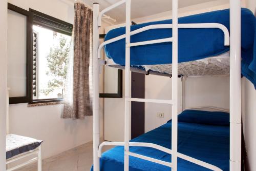 サンタ・マリア・ナヴァッレゼにあるAppartamento Monte Oroの二段ベッド2組、窓が備わる客室です。