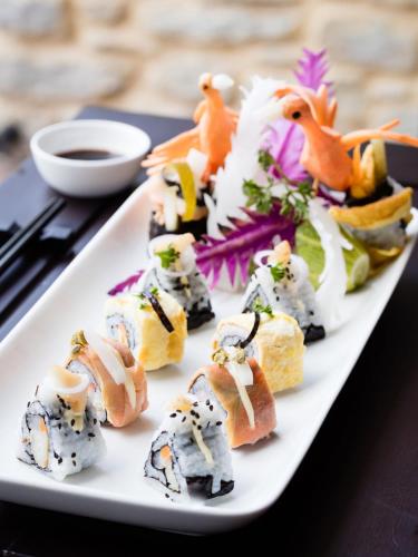 a white plate of sushi on a table at The Pavilions Himalayas The Farm in Pokhara