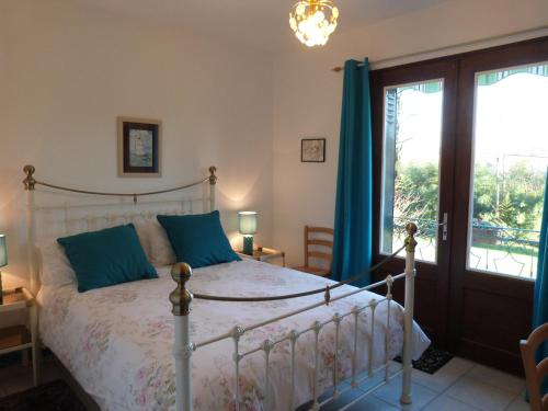 une chambre avec un lit et une grande fenêtre dans l'établissement La Garenne, à Exideuil