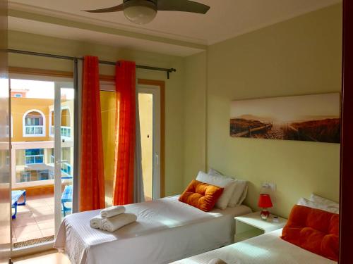a bedroom with two beds and a window with a patio at Turquesa Cotillo in Cotillo