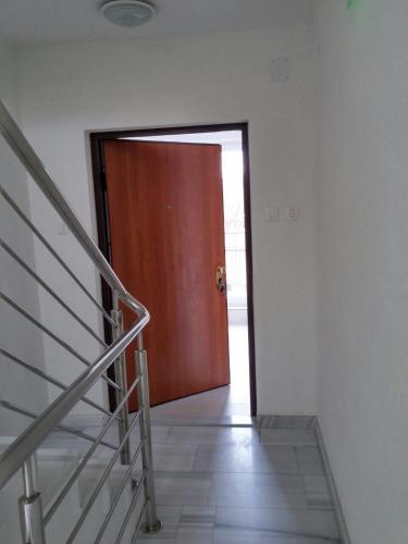 a wooden door in a room with a staircase at Aprtments Belma in Sarajevo