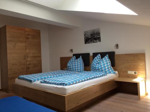 a bedroom with a large bed with blue pillows at Stockingbauer in Leogang