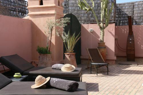 a patio with two tables and chairs with hats on them at Dar Sohane in Marrakesh