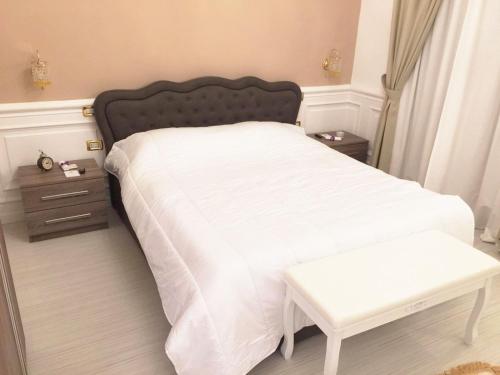 una camera da letto con un letto con un copriletto bianco e un tavolo di i principi.bb a Foggia