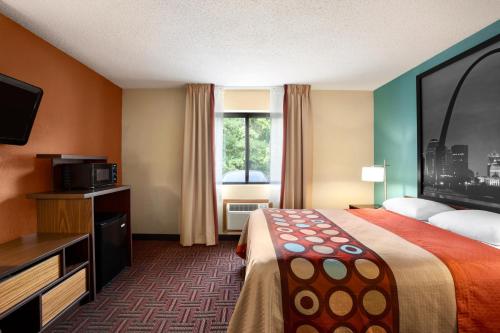 a hotel room with a bed and a television at Super 8 by Wyndham Fairview Heights-St. Louis in Fairview Heights